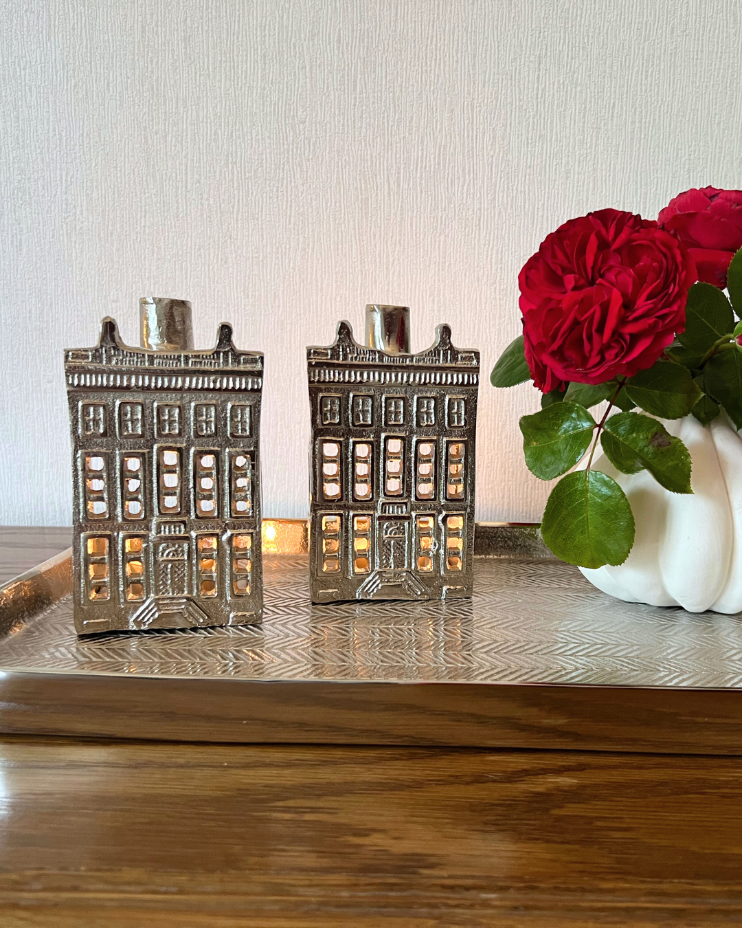 Zwei Canal Häuser sind auf einem Tablett und mit einer Blumenvase, die mit roten Rosen gefüllt ist, dekoriert – alle Wohnaccessoires sind von Rivièra Maison.