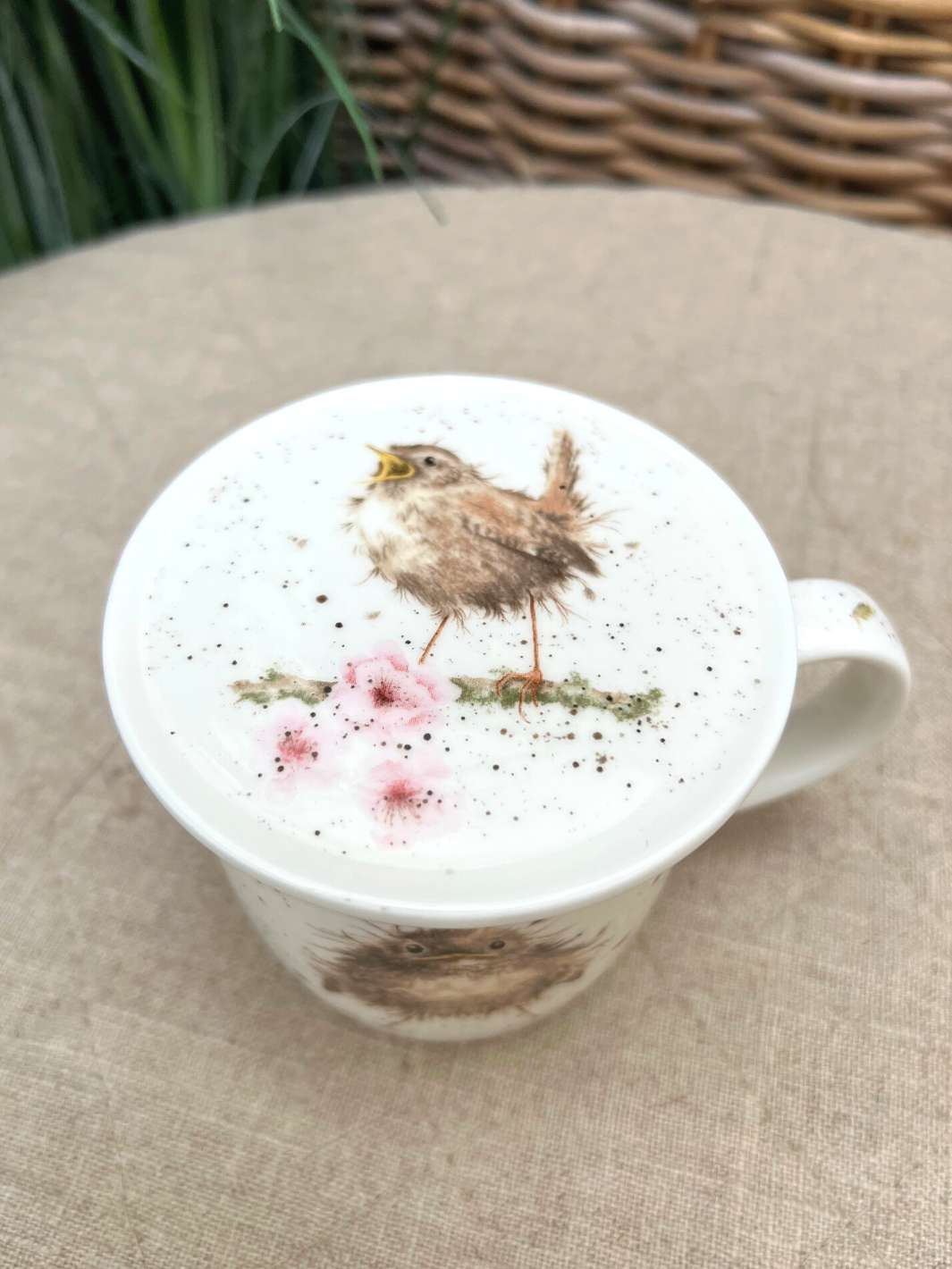 Der Deckel der Vogeltasse von Wrendale Deisgns zeigt einen singenden Piepmatz, der auf einem Kirschblüten Ast sitzt.