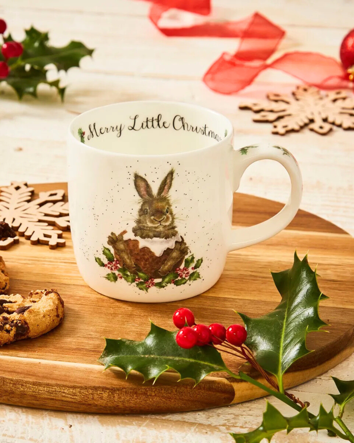 Auf einem Holztablett dekorierte Hasen Tasse mit dem Merry Little Christmas Motiv von Wrendale Designs.