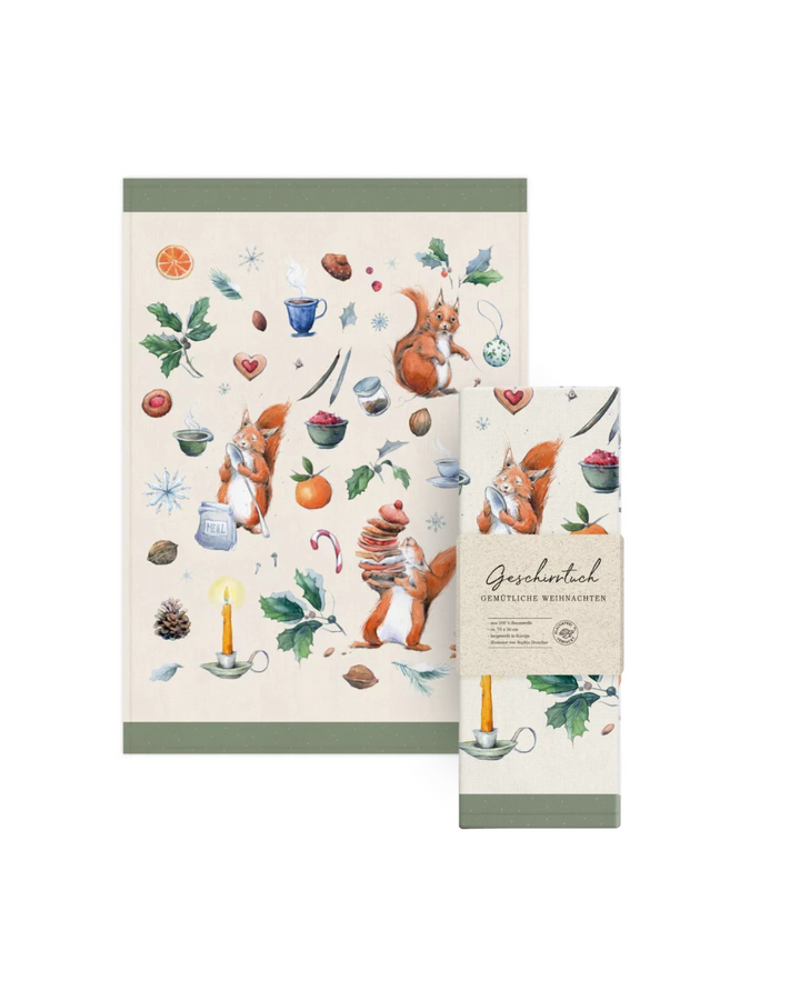 Geschirrtuch „Gemütliche Weihnachten“ vom Grätz Verlag mit Verpacktem Geschirrtuch daneben vor weißem Hintergrund mit weihnachtlichem Eichhörnchen-Motiv und winterlichen Details.