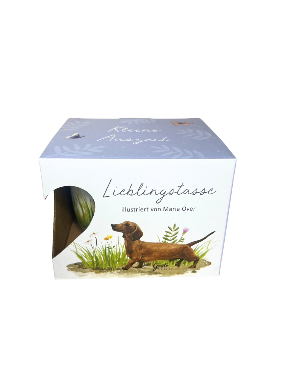 Geschenkverpackung der Lieblingstasse „Hundespaß“ vom Grätz Verlag, illustriert von Maria Over, mit Abbildung eines braunen Dackels auf einer Sommerwiese vor weißem Hintergrund.