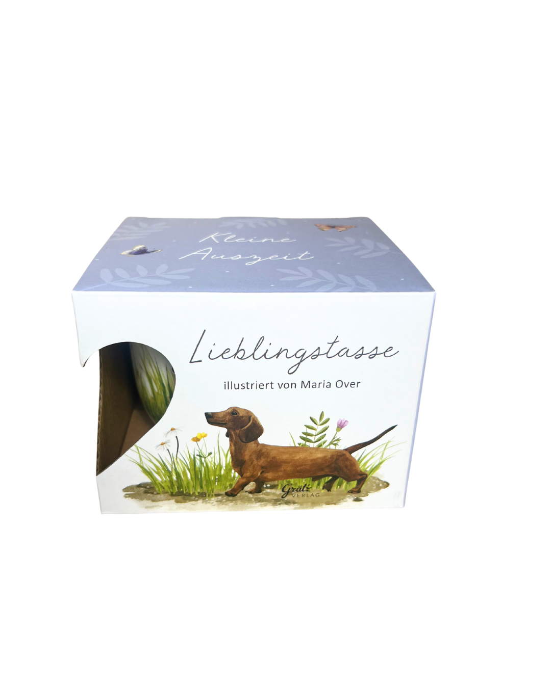 Geschenkverpackung der Lieblingstasse „Hundespaß“ vom Grätz Verlag, illustriert von Maria Over, mit Abbildung eines braunen Dackels auf einer Sommerwiese vor weißem Hintergrund.