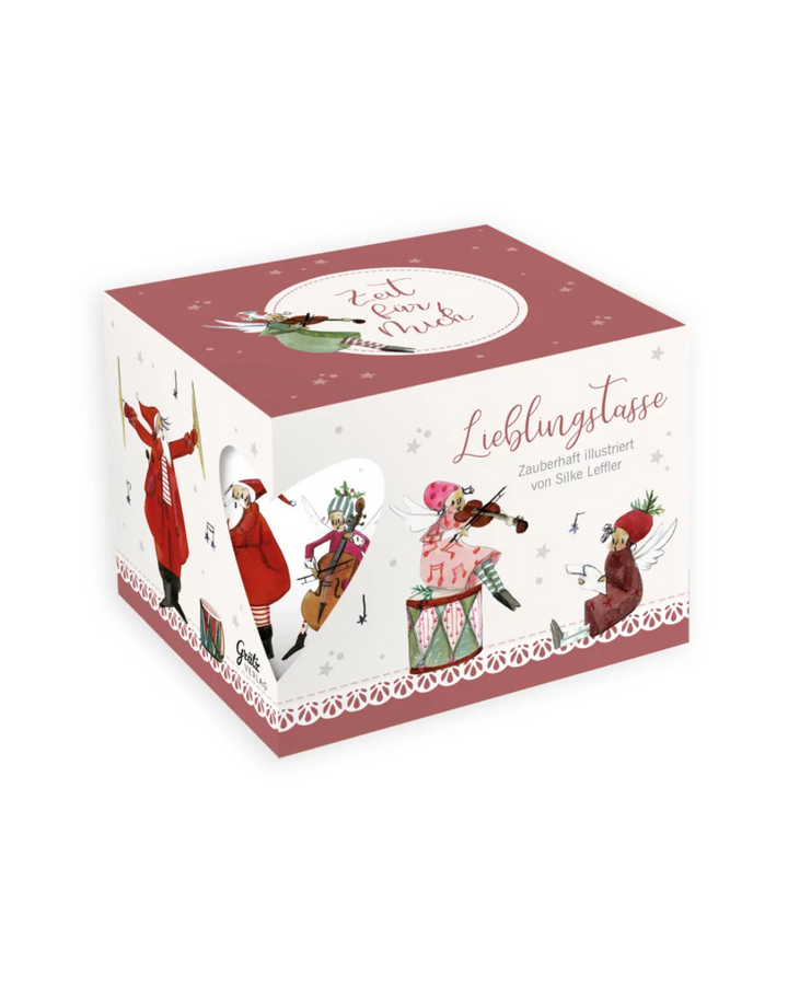 Geschenkverpackung der Lieblingstasse „Musikanten“ vom Grätz Verlag vor weißem Hintergrund, verziert mit Illustrationen von Silke Leffler, die Engel und Weihnachtsfiguren beim Musizieren zeigen.