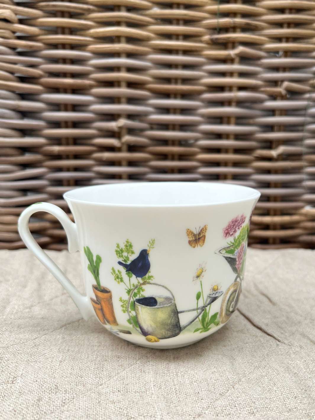 Grätz Verlag Gartenmotiv auf einer schönen Tasse vor braunem Hintergrund.