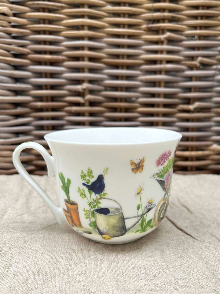 Grätz Verlag Gartenmotiv auf einer schönen Tasse vor braunem Hintergrund.