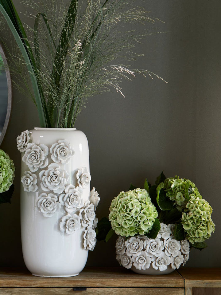 Die große und die kleine Vase von Rivièra Maison mit den Rosen drauf sind nebeneinander dekoriert.