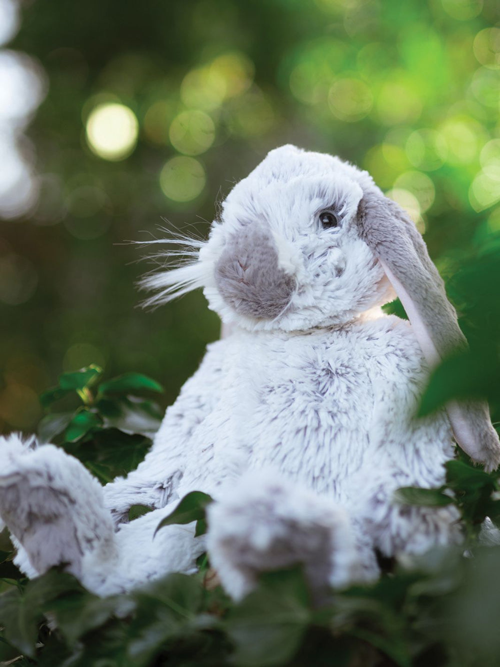 Das große Rosie Hasen Kuscheltier von Wrendale Designs sitzt im Grünen.