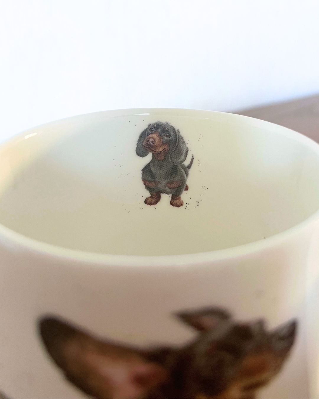Auch im Inneren zeigt die Porzellan Tasse von Royal Worcester ein Dackel Motiv von Wrendale Designs.