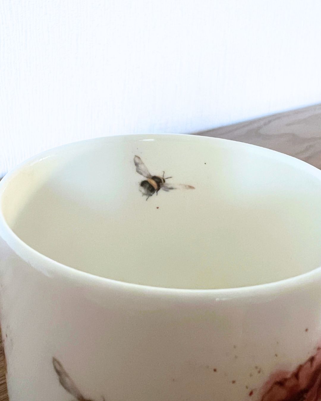 Eine kleine Hummel fliegt als Motiv im Inneren der Tasse von Wrendale Designs.