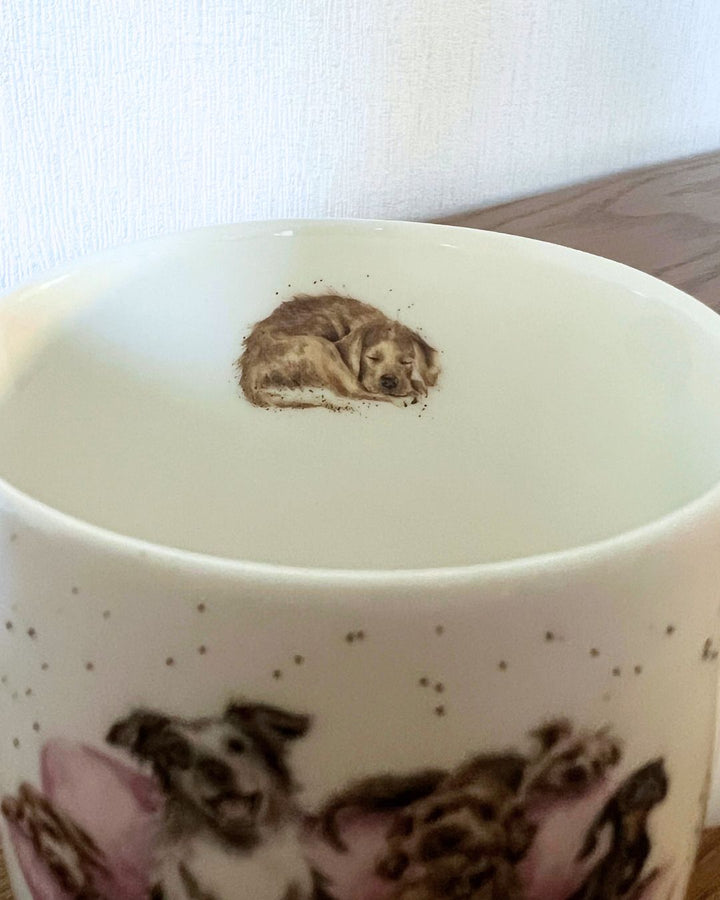 Das Innenmotiv der Movie Night Hunde Tasse von Wrendale Designs zeigt einen schlafenden hellbraunen Hund.