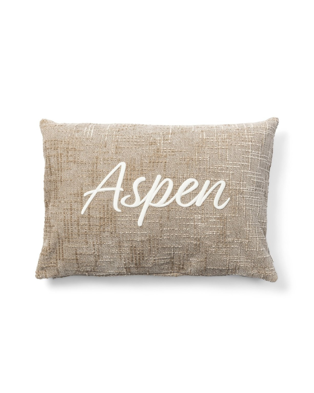 Vorderseite des beigen Kissenbezugs mit weißem „Aspen“-Schriftzug von Rivièra Maison vor weißem Hintergrund.
