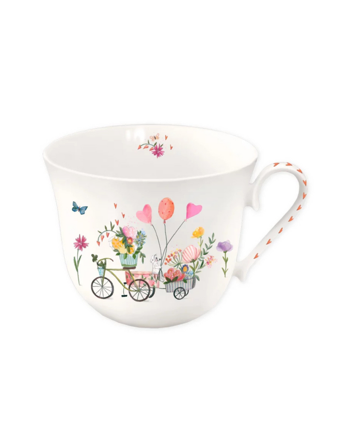 Hier ist deine neue Lieblingstasse "Auf ins Glück" vom Grätz Verlag mit Fahrrädern, Blumen und Luftballons illustriert von Silke Leffler vor einem weißen Hintergrund.