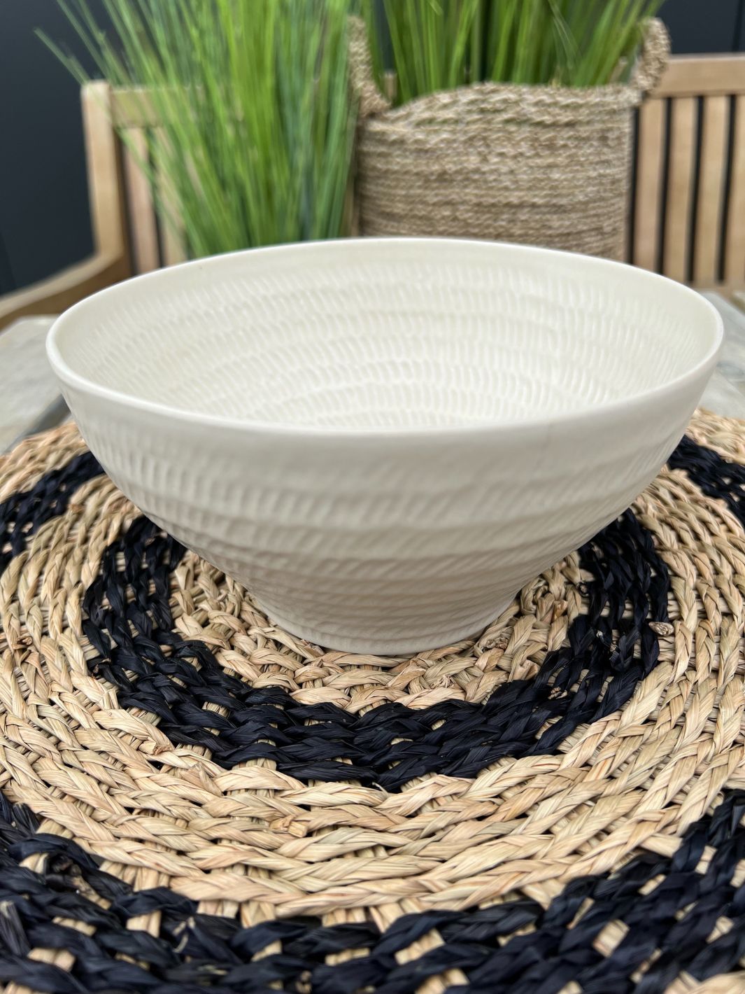 Die weiße Marseille Schüssel von Rivièra Maison steht auf einem runden Platzset in schwarz und braun.