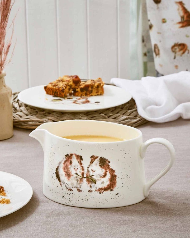 Meerschweinchen Sauciere von Wrendale Designs auf einem gedeckten Tisch.