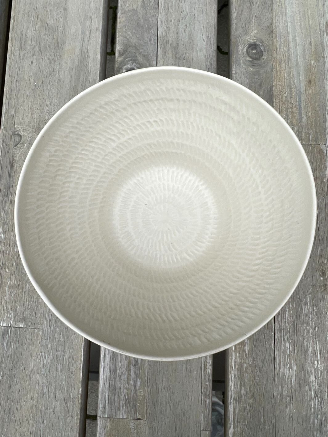 Ansicht von oben in die weiße Marseille Schüssel von Rivièra Maison auf einem Gartentisch.