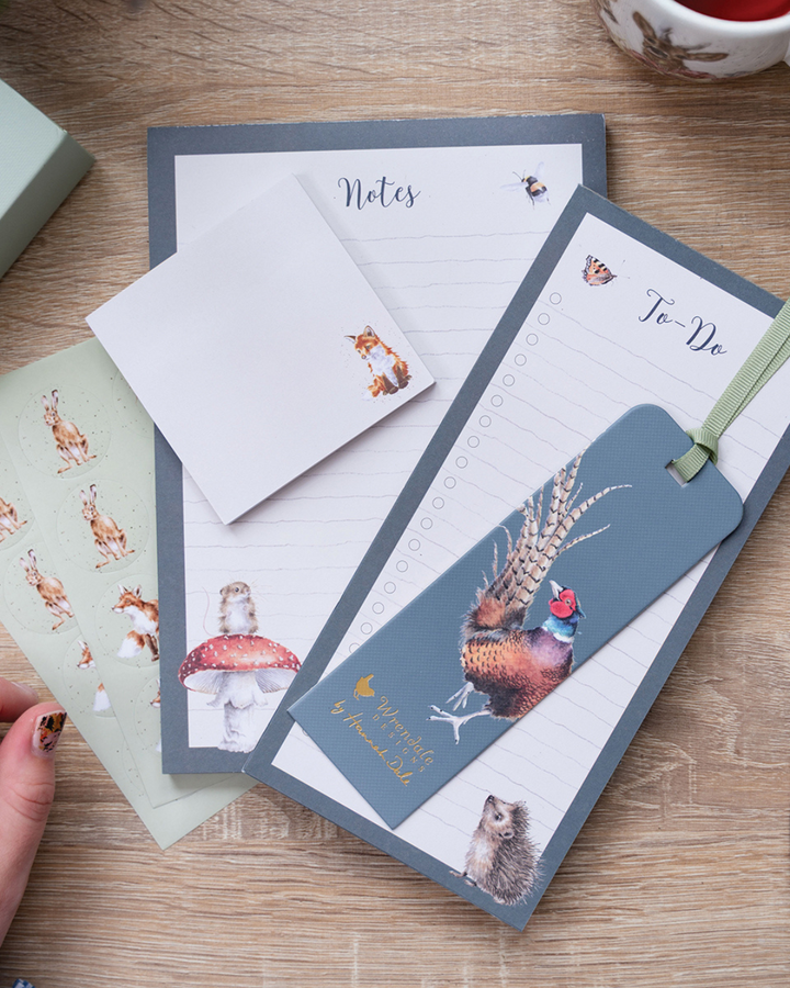 Einzelteile des Wrendale Designs Schreibtisch-Sets mit Tierillustrationen von Hannah Dale, arrangiert auf einem Holztisch.