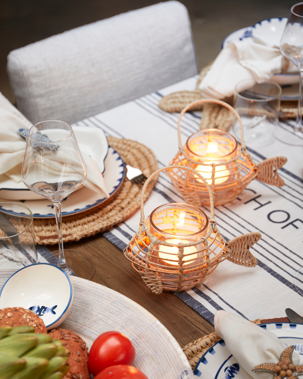 Rivièra Maison Windlichter aus Rattan in Form von Fischen dekoriert auf einem Esstisch mit der Como Catch Serie.