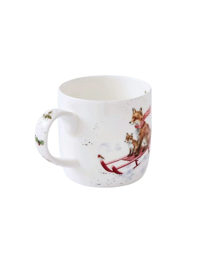 Rückseite der Wrendale Designs Weihnachtstasse „The Sleigh Ride“ mit verschneitem Design und Stechpalmenblättern am Henkel vor weißem Hintergrund.