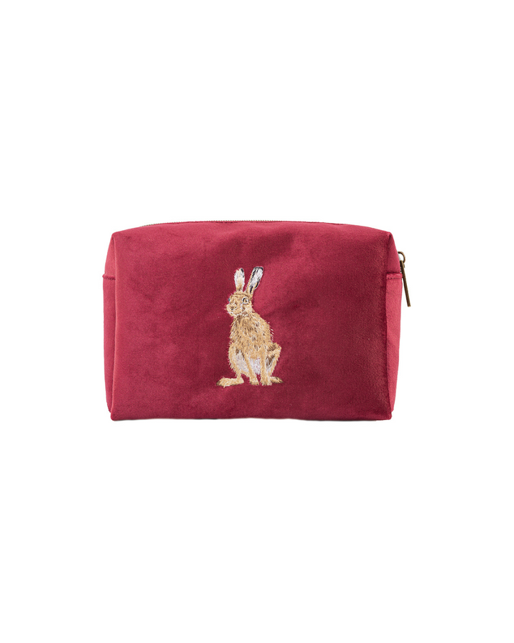 Bordeauxrote Schminktasche von Wrendale Designs mit gesticktem Hasenmotiv nach einer Illustration von Hannah Dale, freigestellt vor weißem Hintergrund.