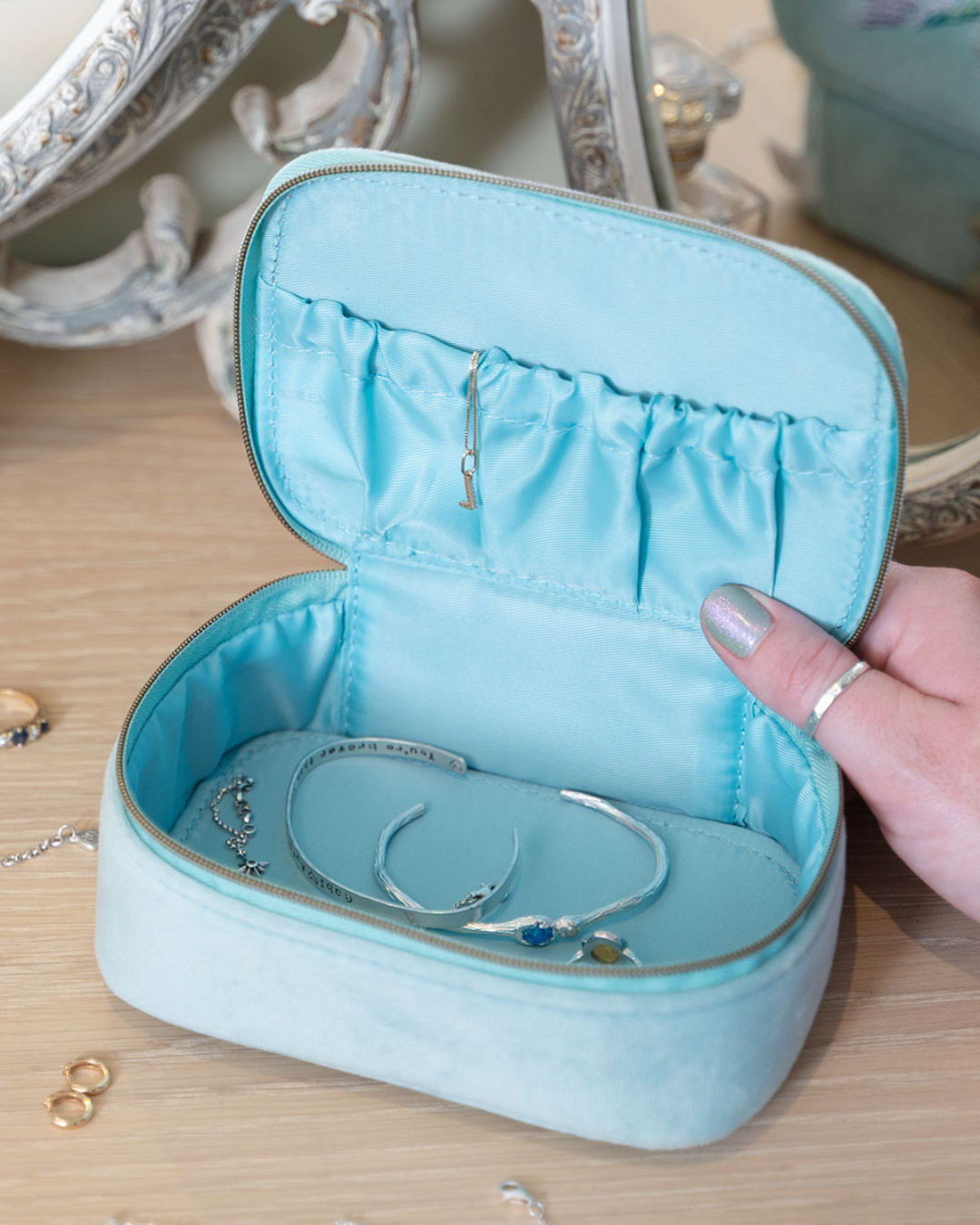 Offene Kolibri-Schmucktasche von Wrendale Designs, gefüllt mit Schmuck auf einem Holzschminktisch