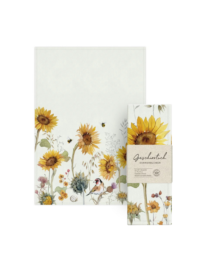 Geschirrtuch und verpacktes Geschirrtuch mit Sonnenblumen-Motiv vom Grätz Verlag vor weißem Hintergrund.
