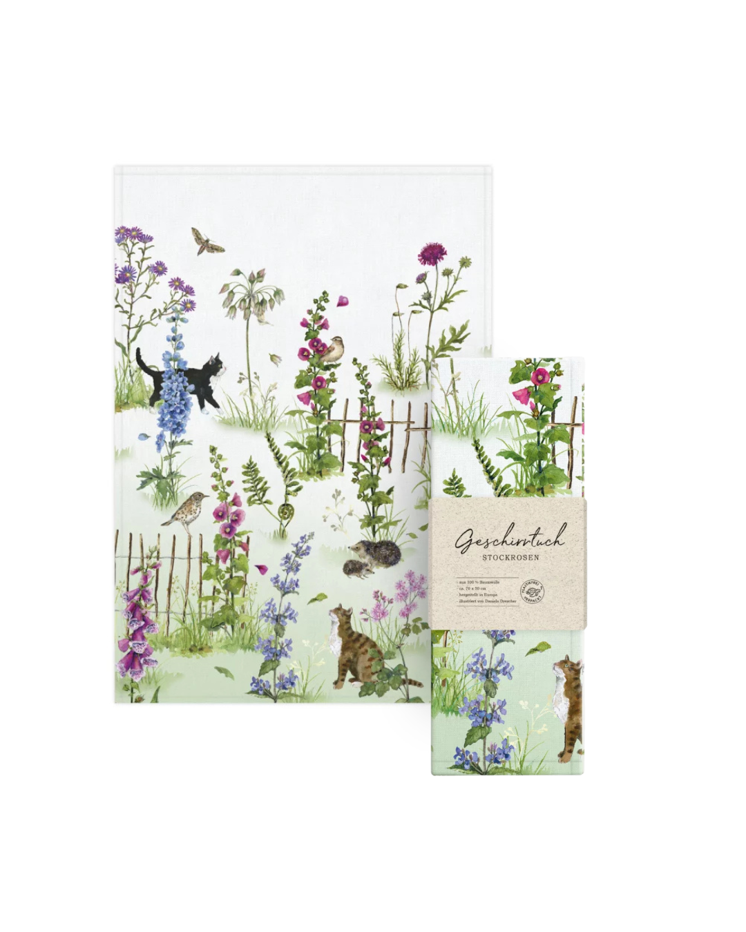 Geschirrtuch Stockrosen vom Grätz Verlag zusammen mit der Verpackung. Sommerliches Motiv von Daniela Drescher mit Blüten, Tieren und Gartenzaun.