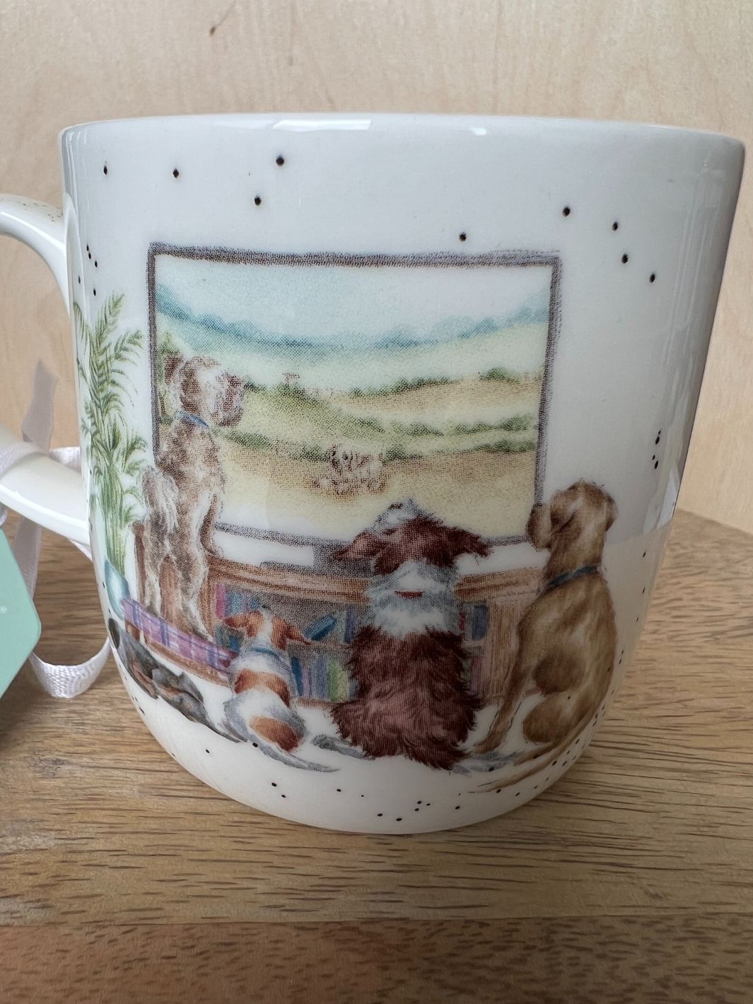 Auf der Rückseite dieser Porzellantasse von Wrendale Designs machen fünf Hundefreunde einen gemeinsamen Fernsehabend.