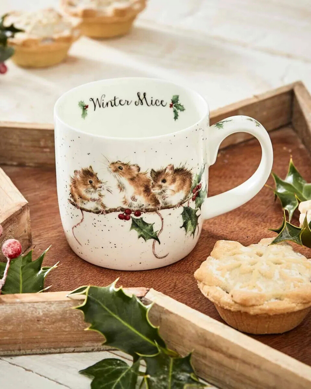 Weihnachtliche Tasse mit einem Mäuse Motiv und der Aufschrift "Winter Mice" im Inneren von Wrendale Designs auf einem sternförmigen Holztablett.