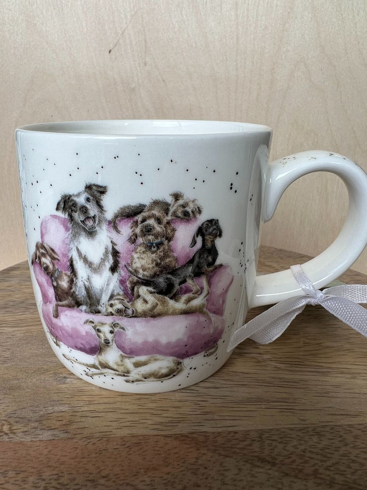 Die Tasse zeigt das Motiv Movie Night von Wrendale Designs mit ganz vielen Hunden, die es sich auf einer pinken Couch bequem gemacht haben.