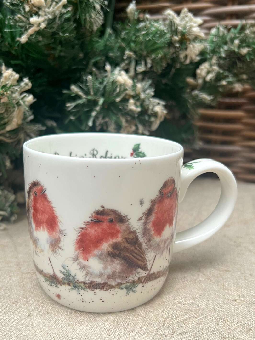 Niedlich gestaltete Tasse mit weihnachtlichen Rotkehlchen von Wrendale Designs.