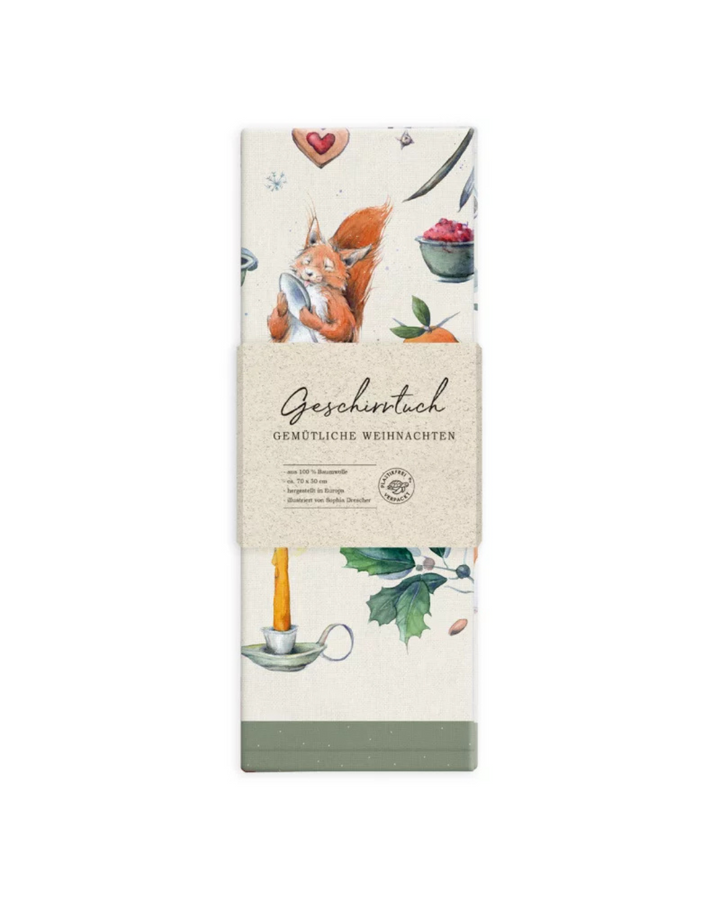 Verpacktes Geschirrtuch „Gemütliche Weihnachten“ vom Grätz Verlag mit Eichhörnchen-Illustration von Sophia Drescher vor weißem Hintergrund.