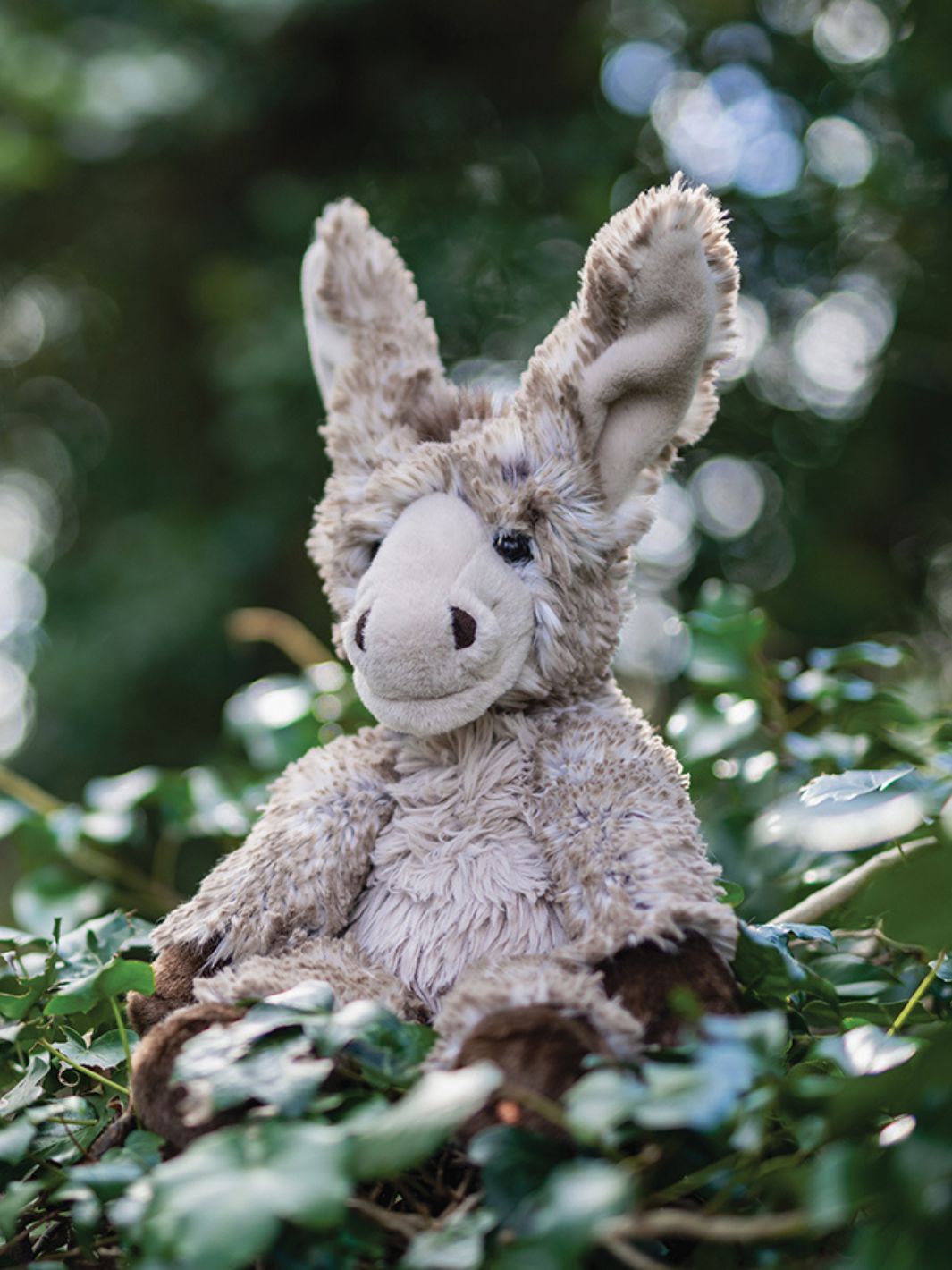 Wrendale Designs Kuscheltier Esel Jack in der Größe L sitzt in der Natur.