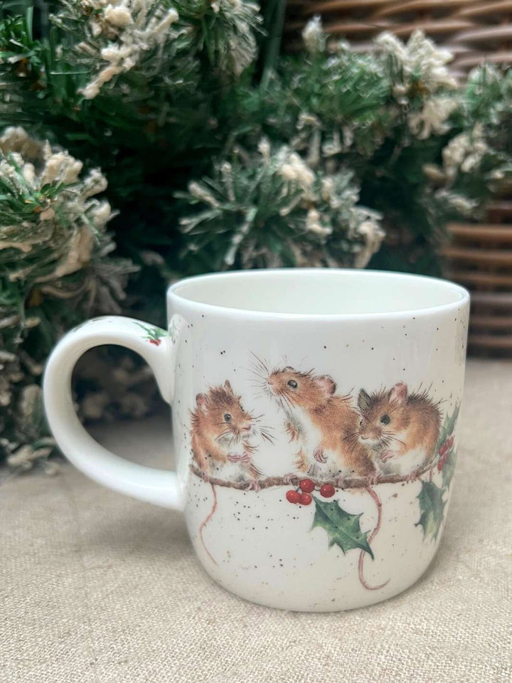 Rückseite der Wrendale Designs Tasse mit  dem Winter Mäusen im Ilex Motiv von Hannah Dale vor weihnachtlichem Hintergrund.