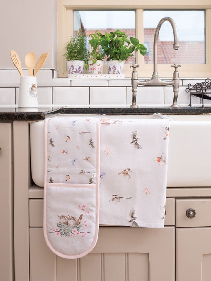 Wrendale Designs Vogel Geschirrtuch dekoriert mit einem Ofenhandschuh in einer Küche.
