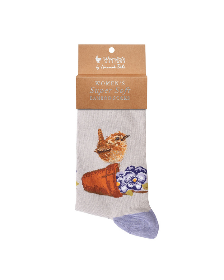 Rosa und lila Zaunkönig Socken von Wrendale Designs mit der braunen Verpackung vor weißem Hintergrund.
