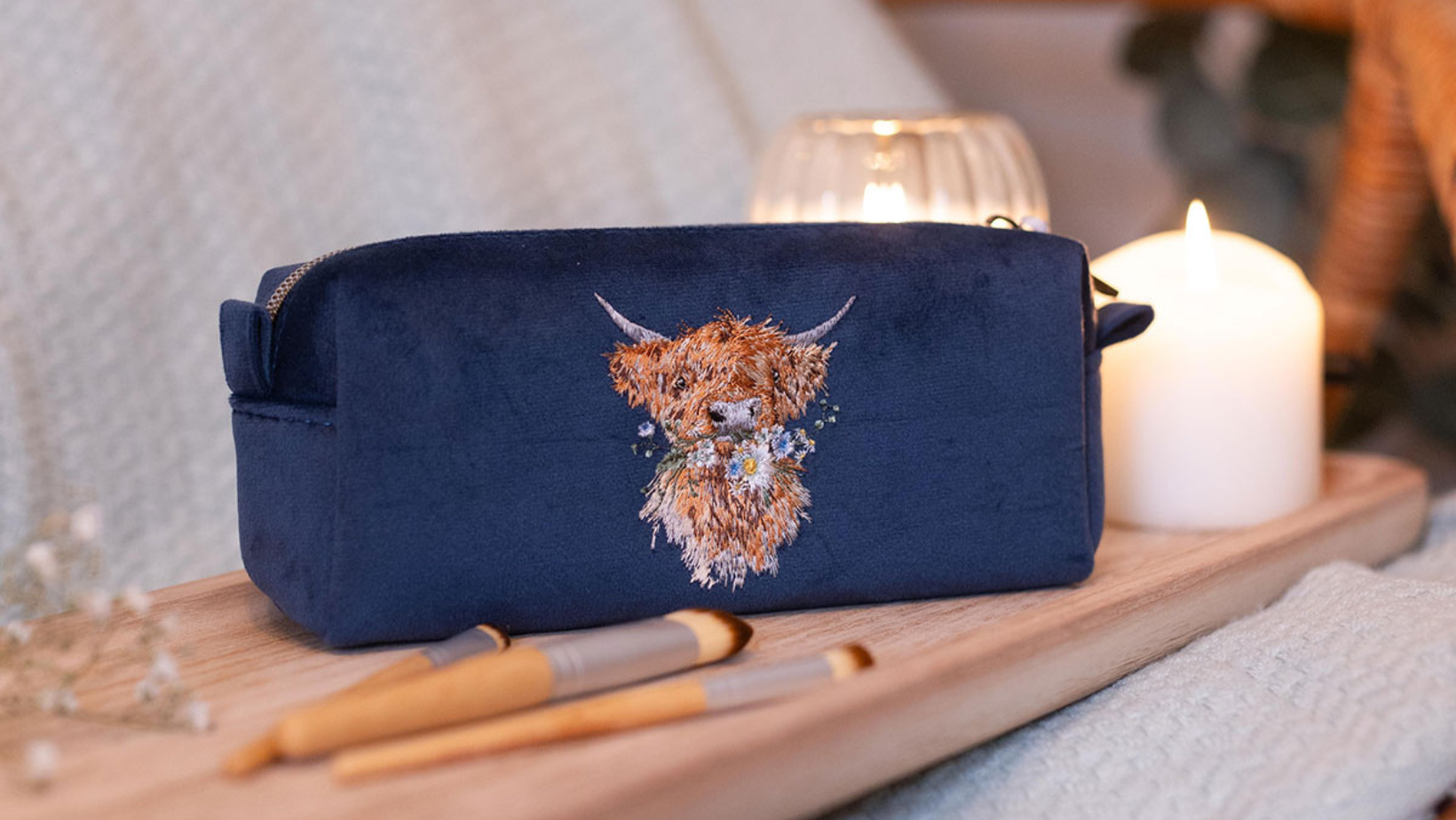 Mit einer Hochland Kuh bestickte Kosmetiktasche von Wrendale Designs.