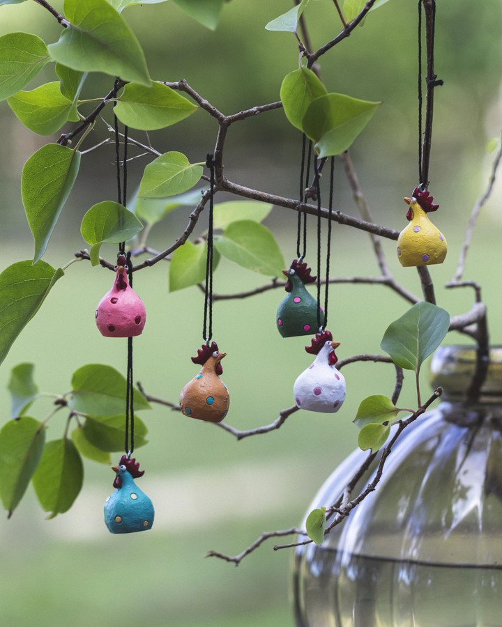 Hängende Poppy-Hühner von Nääsgränsgården dekorativ an einem Ast im Freien aufgehängt