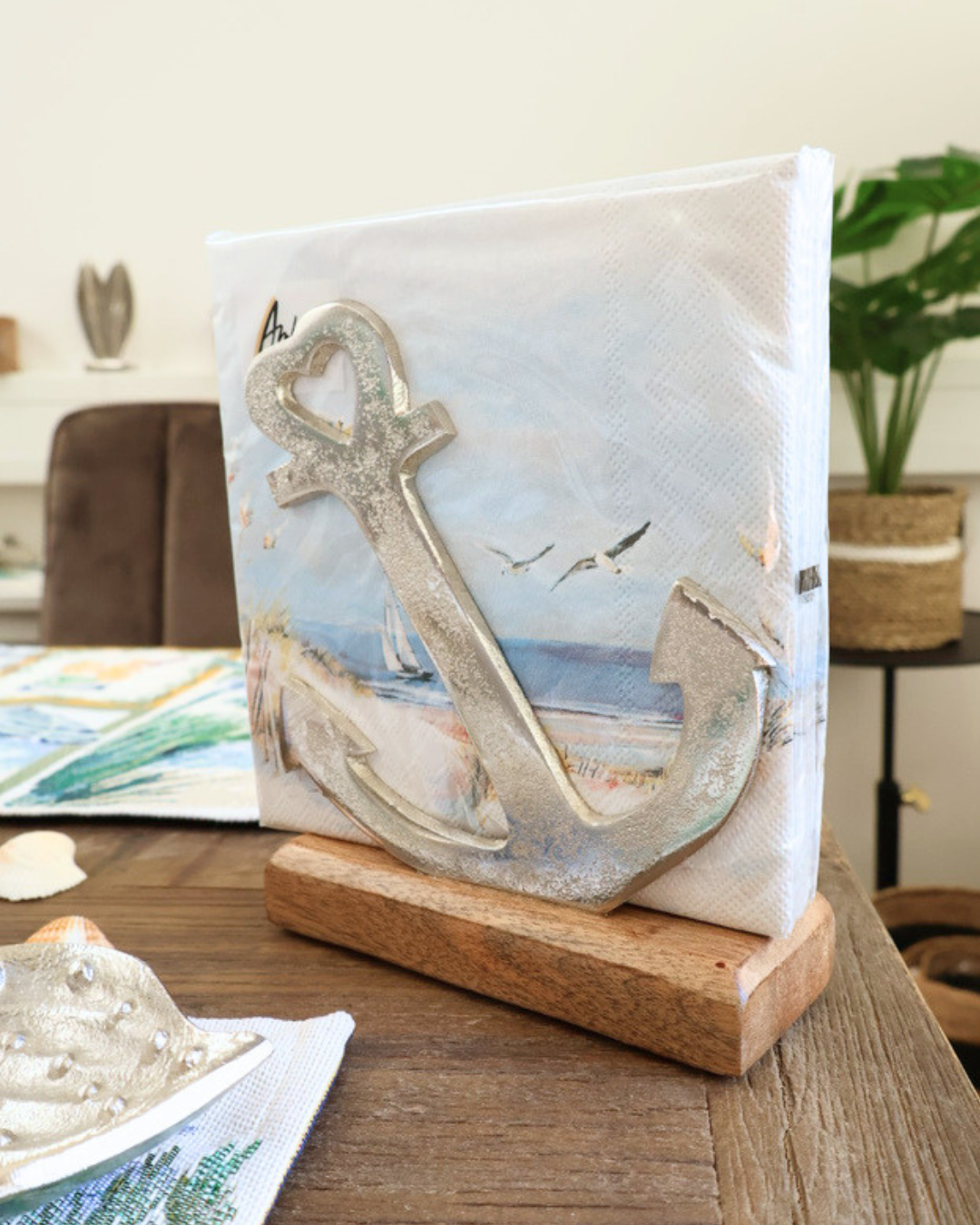 Anker Serviettenhalter "Sailing at Sea" mit Herz Details von Ambiente. Im Serviettenhalter liegen Maritime Servietten. Der Halter liegt auf einem maritim dekorierten Tisch.