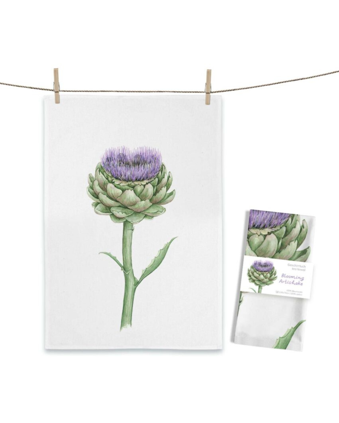 Artischocken Geschirrtuch Blooming Artichoke von Maluu mit blühender Artischocke in Grün und Lila auf weißem Küchentuch an Leine aufgehängt