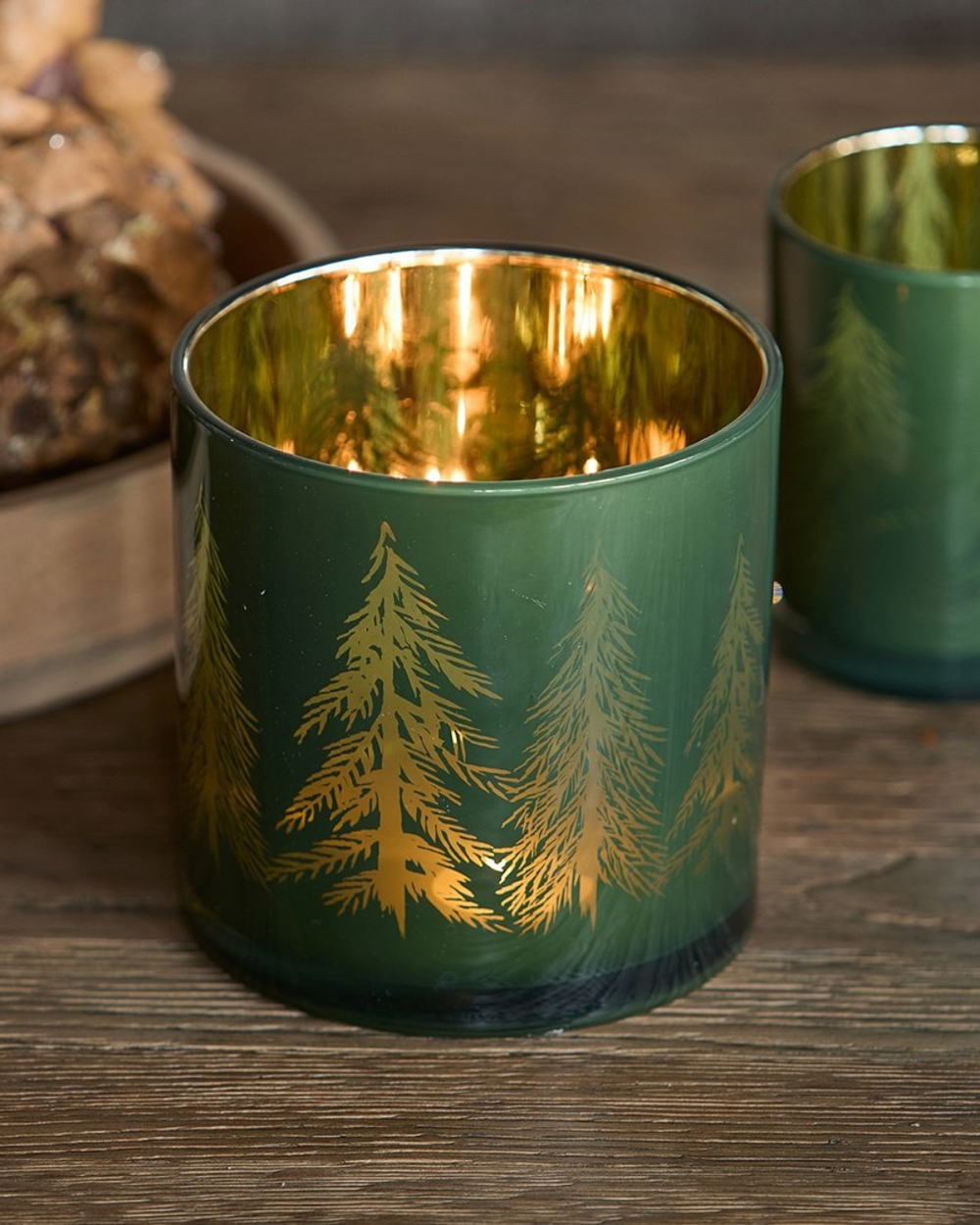 „Leuchtendes Winter Forest Windlicht in Grün und Gold auf Holztisch“