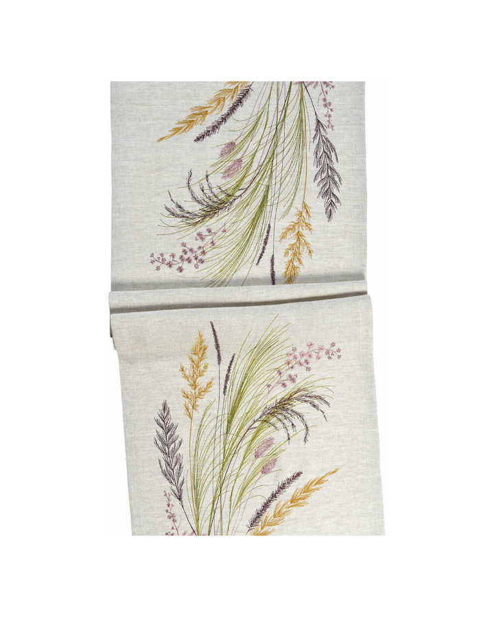 Tischläufer Chatham von Sander vor weißem Hintergrund. Der naturfarbene Leinenstoff ist mit kunstvoll gestickten Gräsern in Grün-, Gold- und Violetttönen – ein exklusives Wohntextil.