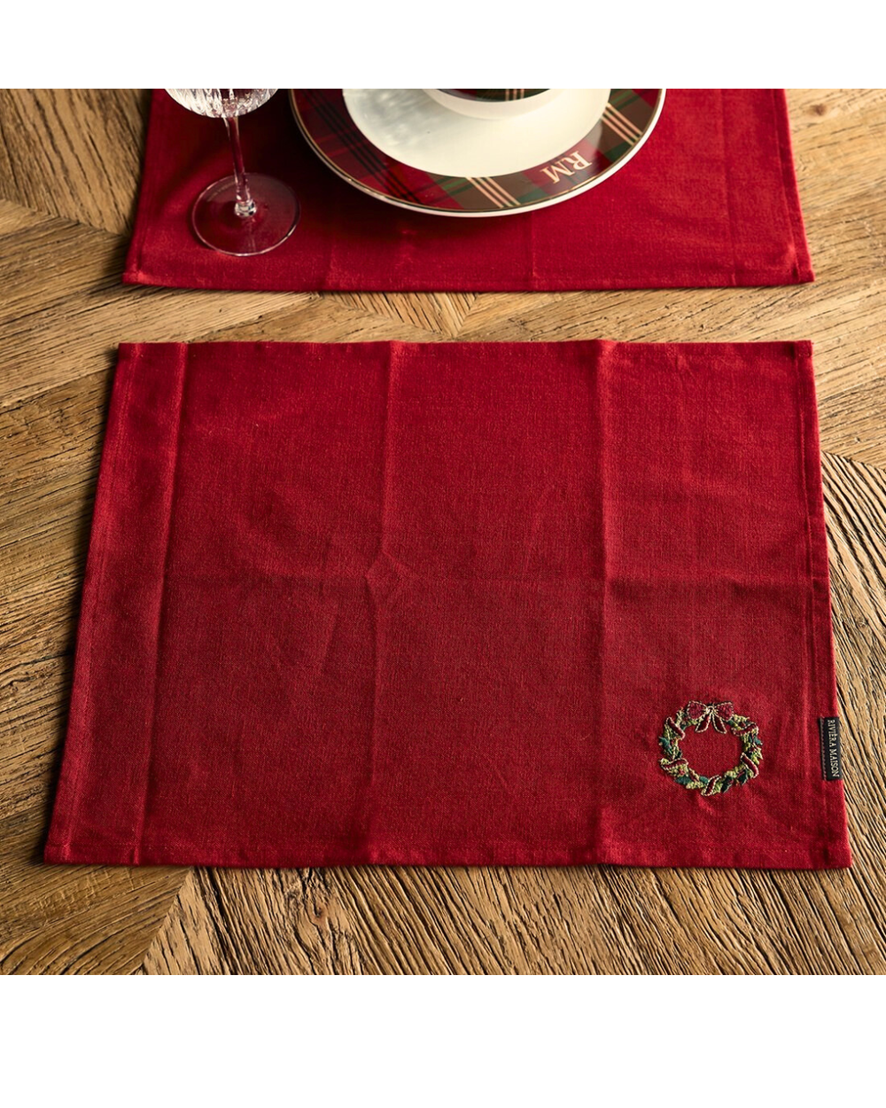 „Festliches Platzset in Rot mit Kranzmotiv von Rivièra Maison auf Holztisch“