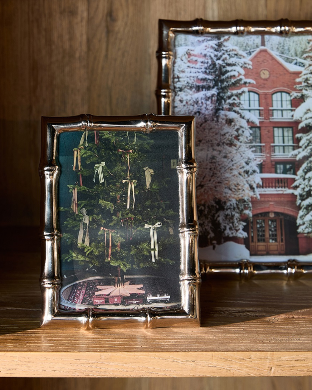 "Bamboo" Bilderrahmen von Rivièra Maison auf einem hellen Holzschrank und einem weiteren größeren "Bamboo" Bilderrahmen im Hintergrund. Beide Bilderrahmen enthalten Weinachtsfotos.