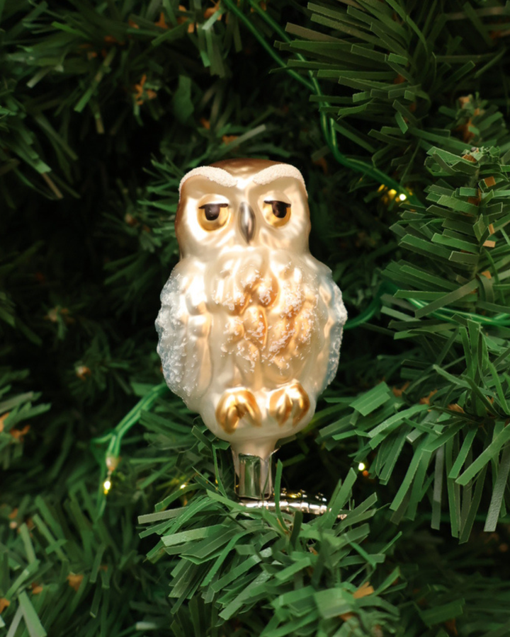 Dekorierter Weihnachtsbaumschmuck "Eule" zum klemmen von Inge Glas hängt an Tannenbaum. Zu sehen ist eine weiß/braun/goldene Eule welche in die Kamera schaut.