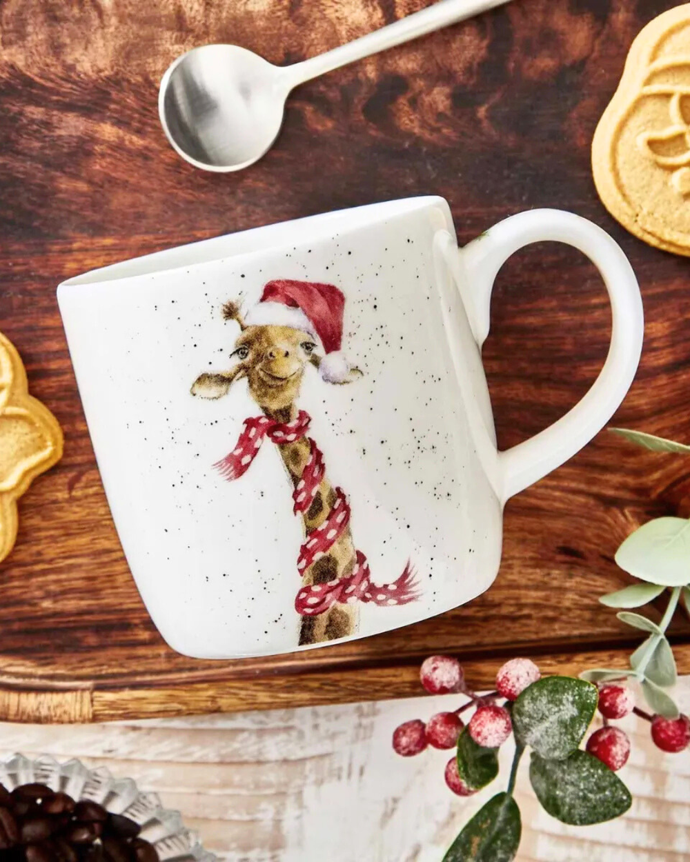 Dekorierte Szene mit der Giraffen-Tasse von Wrendale Designs auf einem Holztisch mit Gebäck und Weihnachtsdeko.