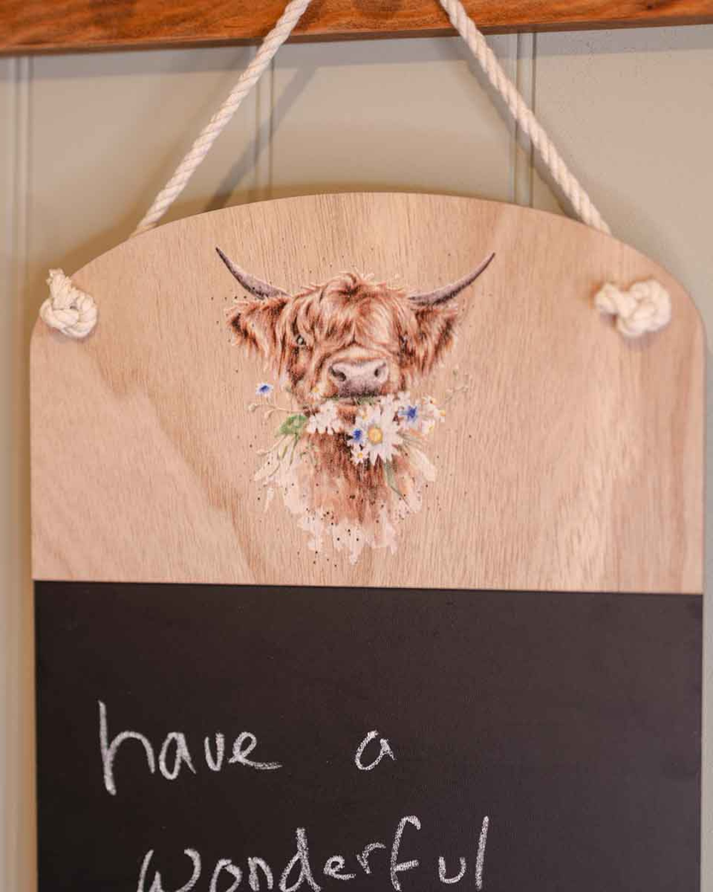 Detailaufnahme der Hochlandkuh-Illustration „Daisy Coo“ von Wrendale Designs auf dem oberen Holzbereich der Kreidetafel, mit Blumenmotiv und feinen Aquarelldetails.
