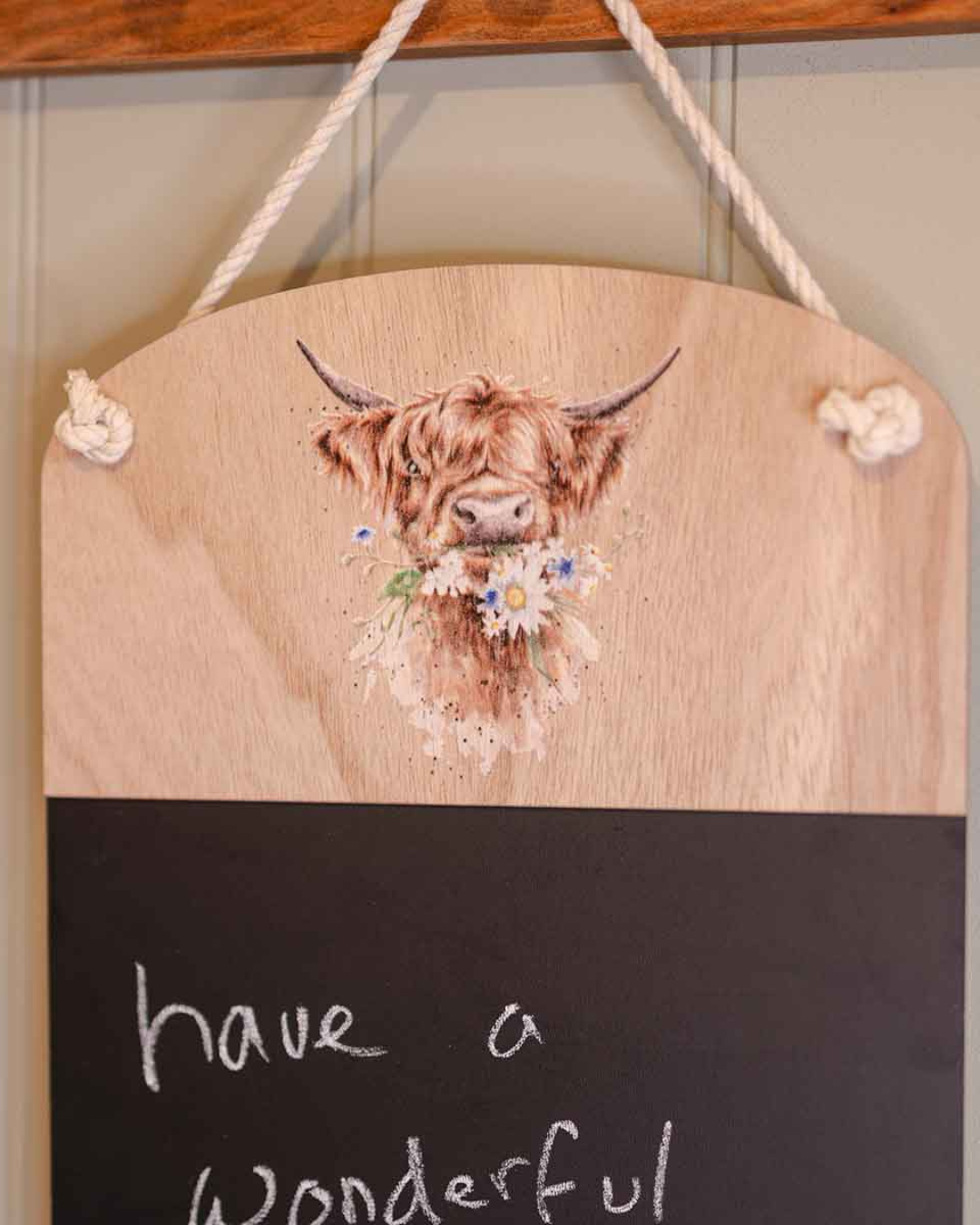 Detailaufnahme der Hochlandkuh-Illustration „Daisy Coo“ von Wrendale Designs auf dem oberen Holzbereich der Kreidetafel, mit Blumenmotiv und feinen Aquarelldetails.