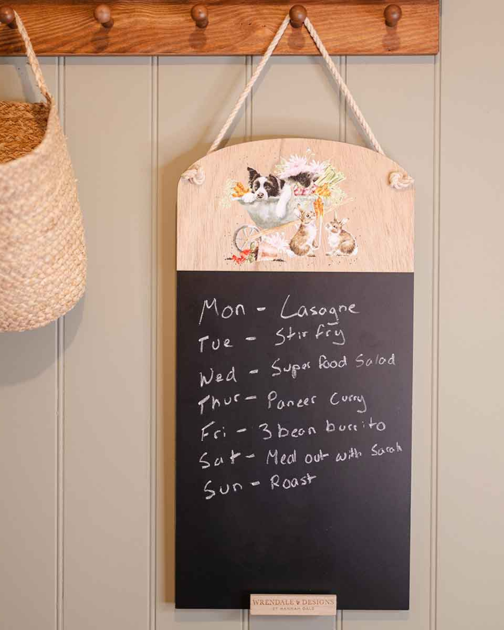 Dekorierte Szene mit der Hunde-Kreidetafel „Sleeping on the Job“ von Wrendale Designs, beschriftet und an einer Wand im Wohnbereich aufgehängt.