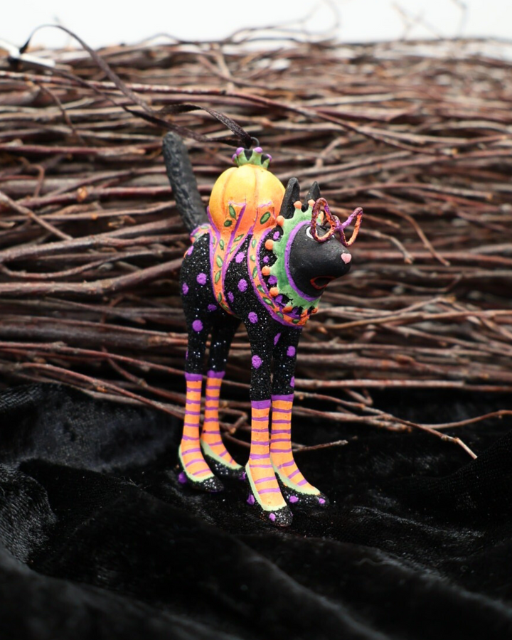 Vor einem Reisigbesen und auf schwarzem Samt dekorierter Katzen Krinkle Mini Black Cat von Patience Brewster.