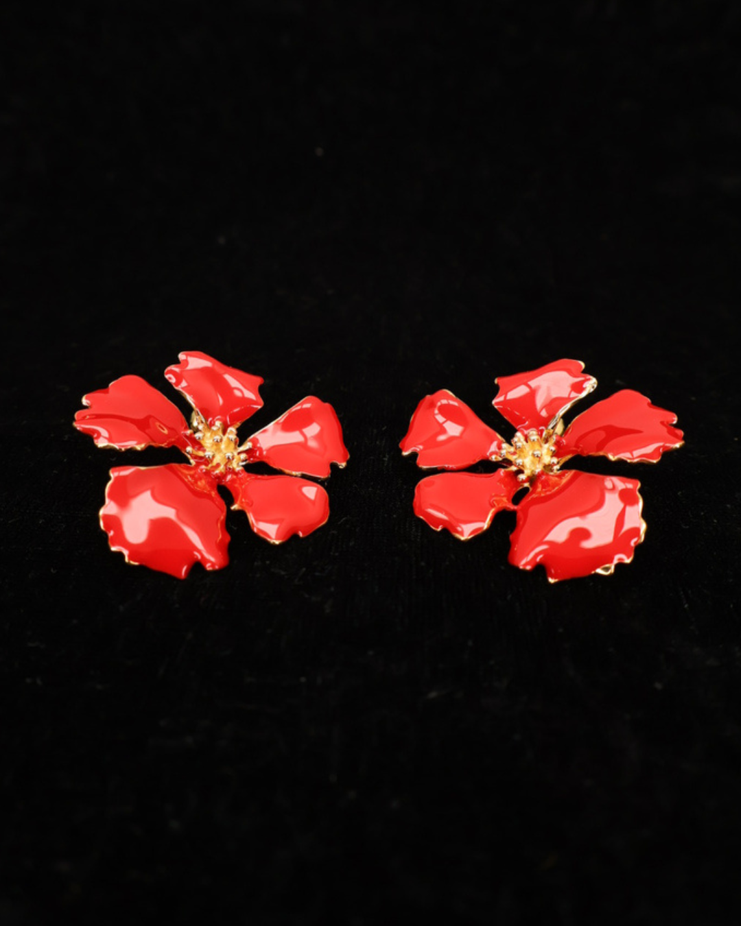 Vorderseite der roten Emaille-Blumen Ohrringe von Dottilove auf schwarzer leicht glitzernder Decke.
